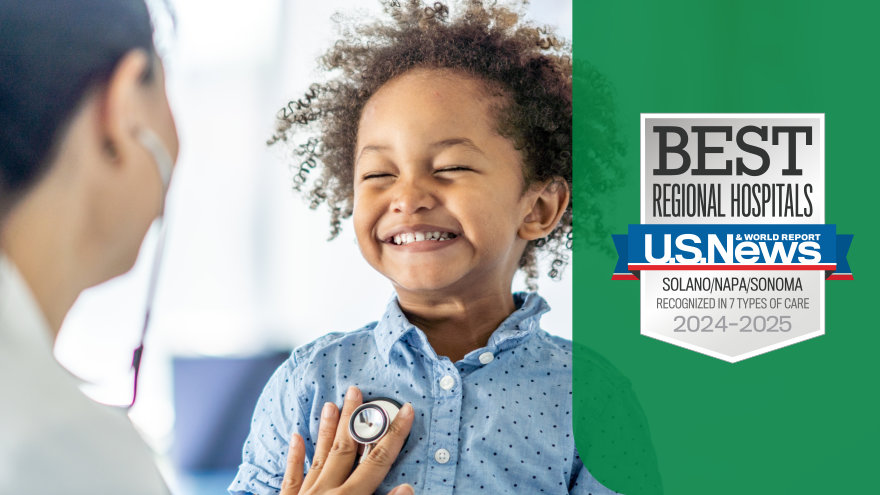 A provider placing her stethoscope on the chest of a smiling child.