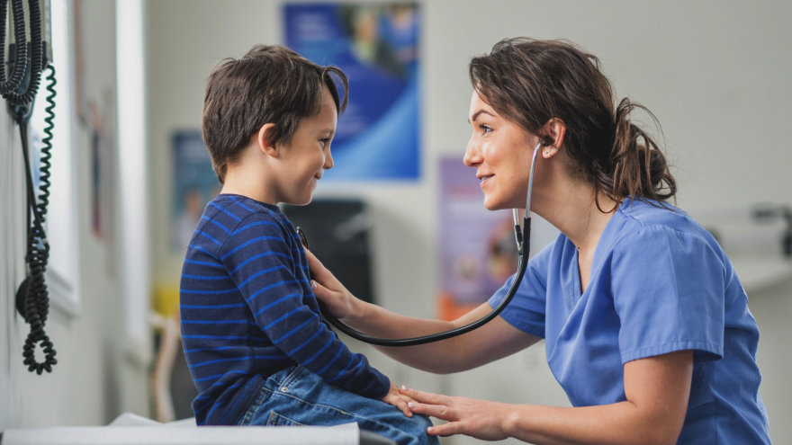 An engaged providers attending to her pediatric patient in a bright, comfortable exam room.